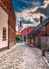Fototapeta na wymiar Old narrow street leading to the medieval temple, photo was taken in an old European town