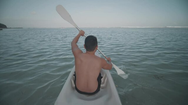 Indonesian Man Canoeing Paddling Canoe at Gunung Payung Beach, Bali, Indonesia Slow Motion