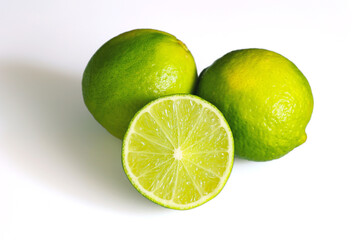 Close up composition of fresh green lime whole and cut isolated on white background.