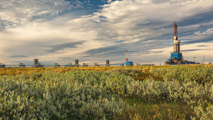 The summer landscape of the Arctic tundra against the background of infrastructure for drilling...