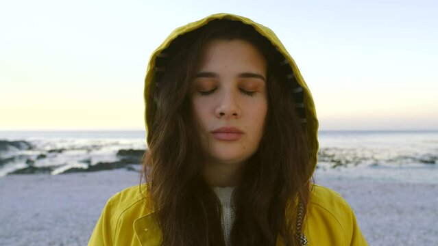 Portrait of anxious ocean, marine environmentalist and nature conservation volunteer stressed about climate change or global warming. Young student meditating on a beach and breathing to calm nerves