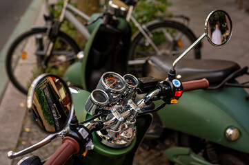 View to the chromed instruments on the handlebars of a vintage style scooter.