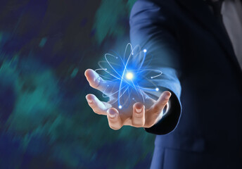 Man holding virtual model of atom on color background, closeup