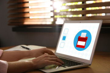 Woman voting online via laptop at table, closeup