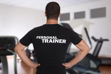 Fototapeten Professional personal trainer in gym, back view © New Africa