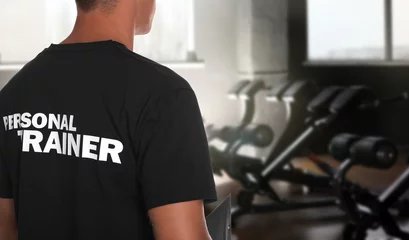 Tuinposter Professional personal trainer in gym. Space for text © New Africa