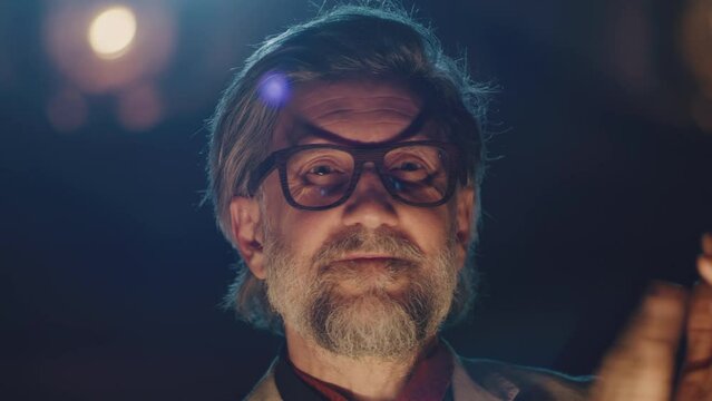 Happy director in glasses and suit smiling and applauding to actors after performance in the theater