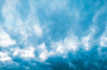 a cloudy blue sky. a cloudscape covering the sky. a background of a cloud covered sky