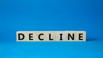 Decline symbol. Concept word Decline on wooden cubes. Beautiful blue background. Business and Decline concept. Copy space.