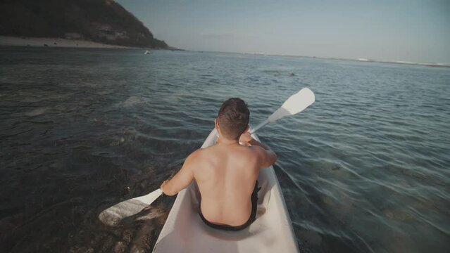 Indonesian Man Canoeing Paddling Canoe at Gunung Payung Beach, Bali, Indonesia Slow Motion