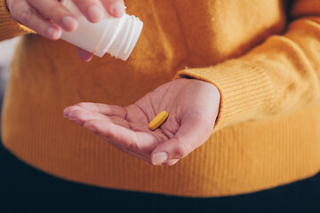 Woman taking a pill from the bottle. Healthy lifestyle concept