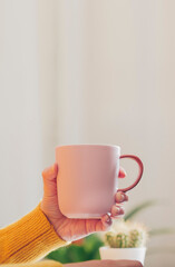 Woman's hands with coffee cup in workspace