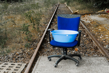Old blue office chair with wheels on railway
