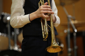 A person holding a musical instrument a trumpet in his hands close up