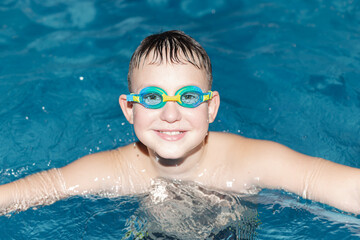 Naklejka premium A happy smiling boy swims in the sea. Healthy lifestyle. Swimming. Sports and recreation