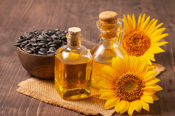 Obraz na płótnie Canvas Closeup photo of sunflower oil with seeds on wooden background. Bio and organic product concept.