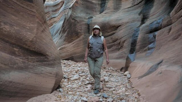 Tourist Walks Along A Picturesque Narrow Canyon Gorge With Curved Wavy Walls