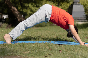 Yoga Kid, Young boy Practicing Yoga Outdoors in the park in Morning, healthy lifestyle concept