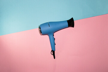 blue hair dryer isolated on blue pink background, creative art modern design
