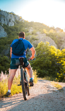 Athlete sport man riding bike outdoors on mountain trail