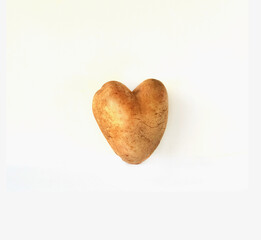 Unnormal vegetables or food waste concept. Ugly potato in the heart shape on isolated white background.