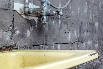 An old washbasin in a shabby place in a poor quarter. Kitchen under repair