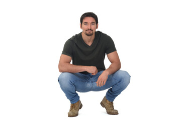 full portrait of a man squatting and looking at camera on white background