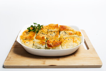 Close-up of greek pie spanakopita on wooden board. Homemade vegan food.