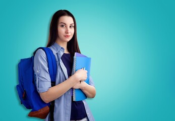 Fototapeta premium Happy young woman wearing a backpack while carrying books and notebooks go to college