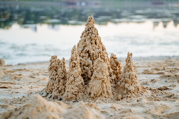 Sand castles are built on the sea coast, sand turrets, no people.