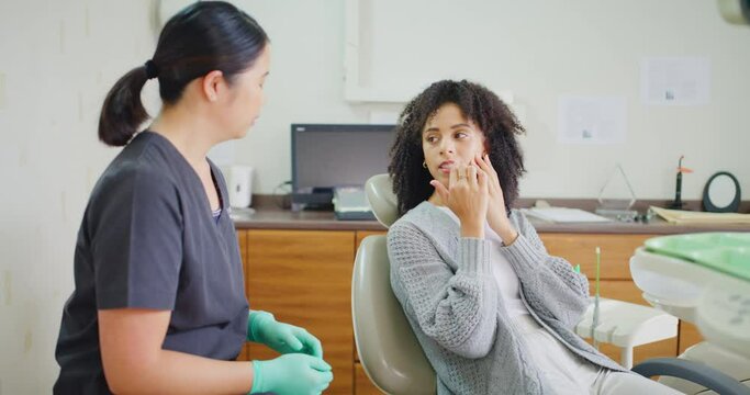 Patient with toothache and dentist consulting and discussing in the doctors rooms. Two women talking about the best treatment for cavity and tooth decay prevention and oral hygiene for teeth and gums