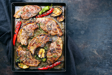 Barbecued lamb saddle back chop steaks with chili and eggplants served as top view on a rustic...