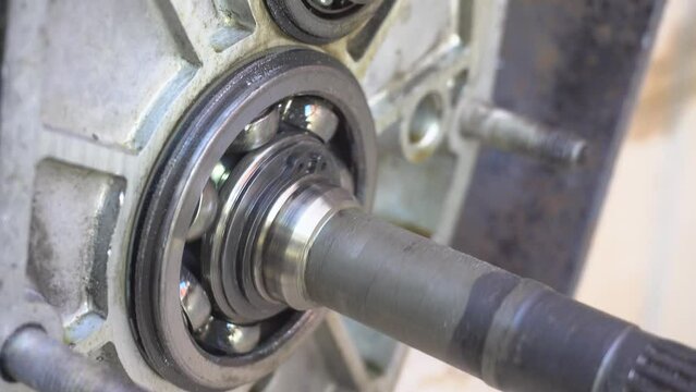 Metal bearing rotation, close-up. Rotation of a bearing in a car gearbox. Old mechanics at work. Aluminum crankcase with bearing