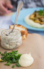 Forshmak with green onion and toasted bread. Seafood restaurant. Baguettes with creamy fish. Herring mousse on restaurant table. 