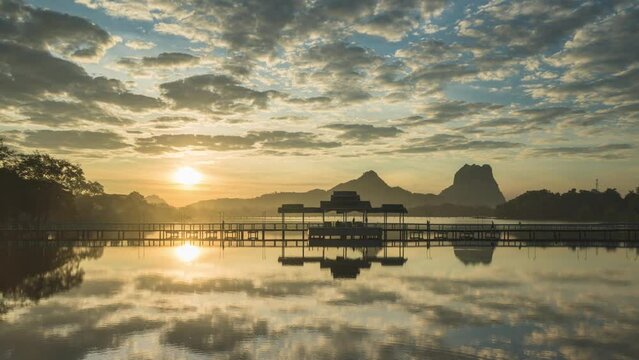A time lapse of the Kan Thar Yar Bridge in 
Hpa-An in Myanmar. Beautiful atmosphere with colored clouds and reflections in the water during the sunrise. Mount Zwegabin in the Background.