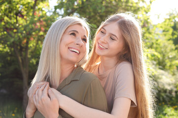 Happy mother with her daughter spending time together in park on sunny day