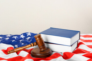Judge's gavel and books on American flag against white background, space for text
