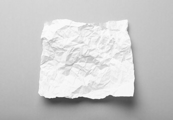 Obraz premium Sheet of white crumpled paper on grey background, top view