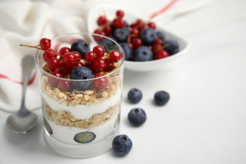 Delicious yogurt parfait with fresh berries on white table, closeup. Space for text