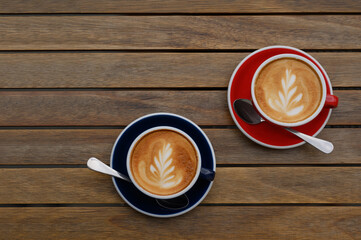 Cups of aromatic coffee on wooden table, flat lay