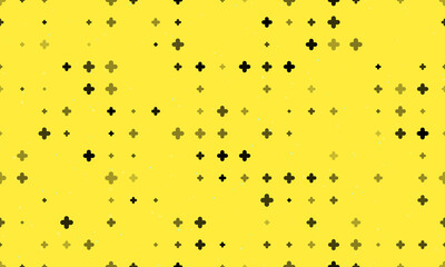 Seamless background pattern of evenly spaced black quatrefoil symbols of different sizes and opacity. Vector illustration on yellow background with stars