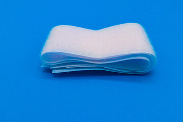 Hook-and-loop fastener white Velcro in closeup on blue background