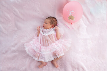 Newborn baby girl sleeping on white fur background. A beautiful newborn girl sleeping on a white soft blanket. Newborn baby sleeping. Sweet studio photoshoot of cute infant child.