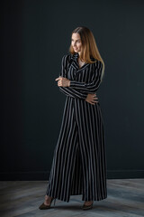 Fototapeta premium portrait of a young attractive woman on a dark background, full growth