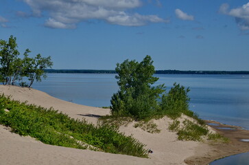 Dunes Beach sand dunes at Sandbanks Provincial Park in Ontario, Canada.   Sandbanks is the largest baymouth barrier dune formation in the world. It is located on Lake Ontario. - obrazy, fototapety, plakaty