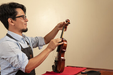 Worker tuning a violin in a workshop