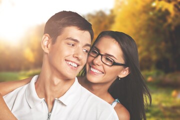 Close up portrait of joyful couple hugging with forest nature in background. Man and woman smiling and having fun together in outdoor leisure activity.