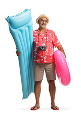 Happy mature male tourist holding a inflatable mattress and a swimming ring