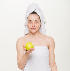 beauty portrait of a cheerful girl with a towel on her head isolated.Facial skin care and health concept.close-up on a white background. girl holding a glass holding an apple brushing her teeth making