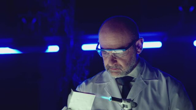 Professional tester testing , burning piece of fireproof building material  by gas torch inside  futuristic laboratory.  Construction engineer doing experiment . Physicist working in lab . Slow motion